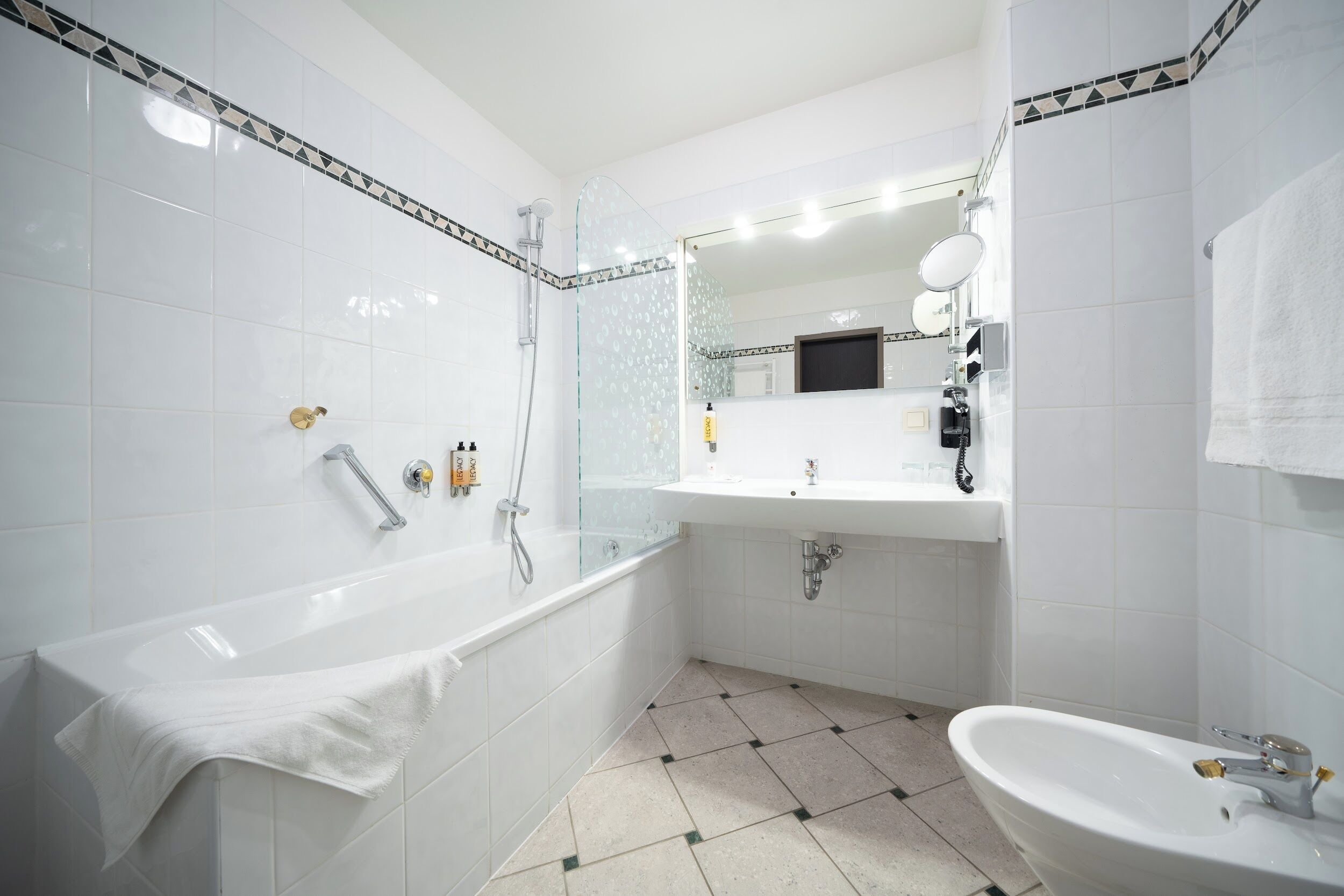 Une salle de bain moderne avec une baignoire, un lavabo et un espace douche.