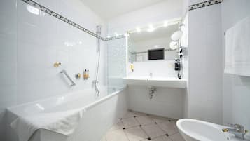 Une salle de bain moderne avec une baignoire, un lavabo et un espace douche.