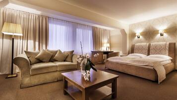 Una habitación de hotel con una cama, un sofá, una mesa de centro y dos lámparas.