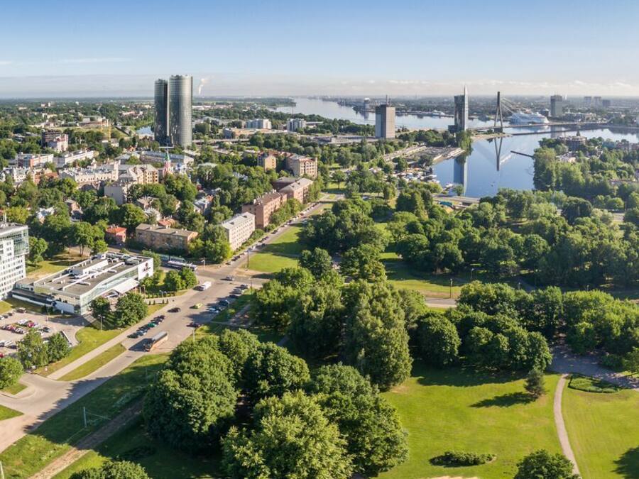 Vista aérea de un paisaje urbano con una mezcla de edificios modernos y antiguos, un río y un puente.