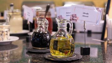 Three glass bottles of olive oil on a counter with labels.