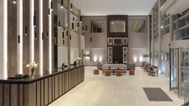 Eine großzügige Lobby mit Empfangsschalter, Sitzgelegenheiten und moderner Einrichtung.