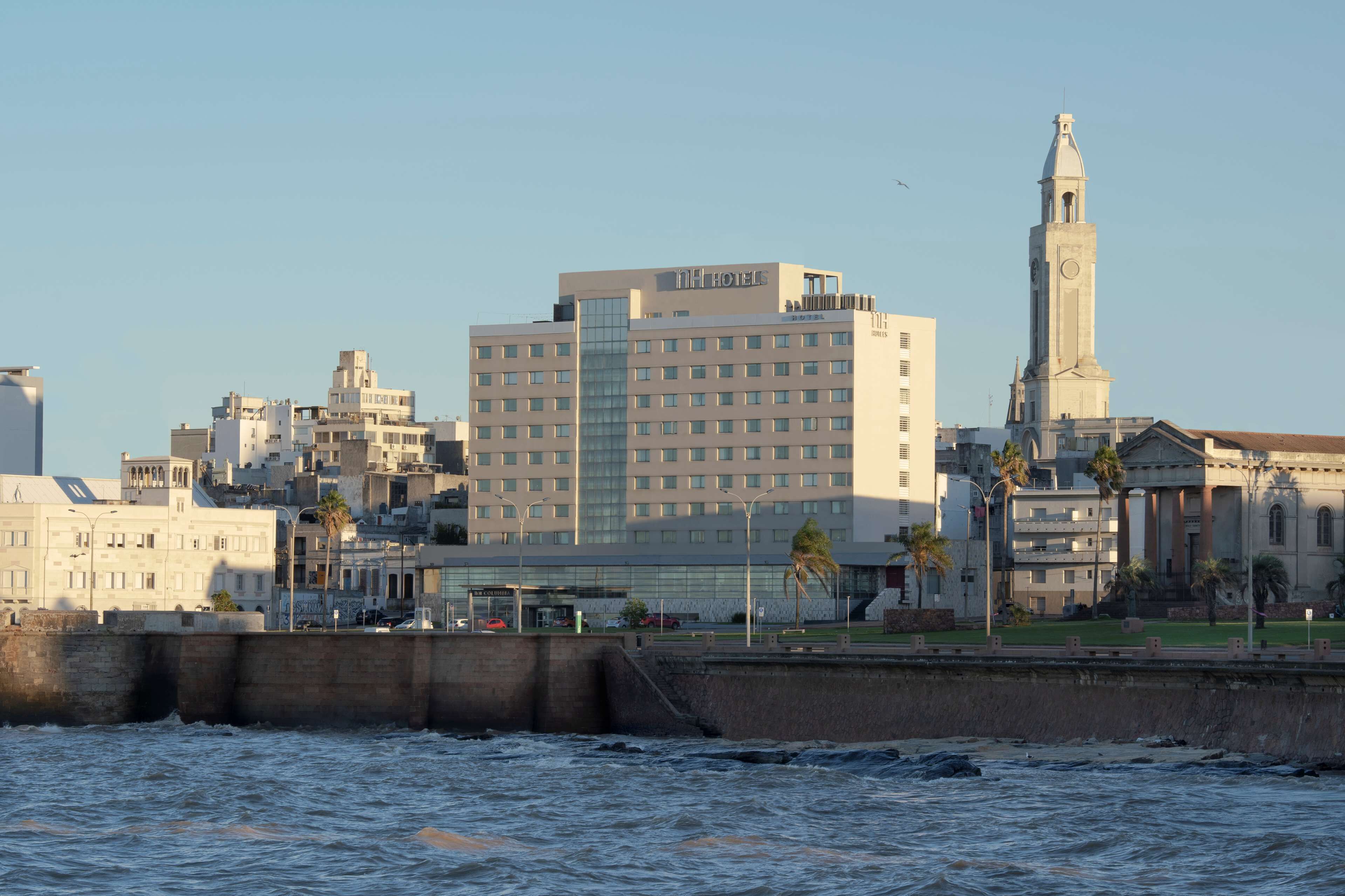 A hotel with a modern design, featuring a prominent clock tower and a large number of windows.