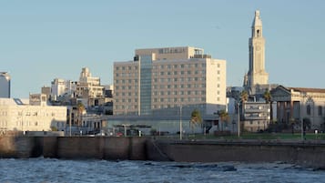 A hotel with a modern design, featuring a prominent clock tower and a large number of windows.