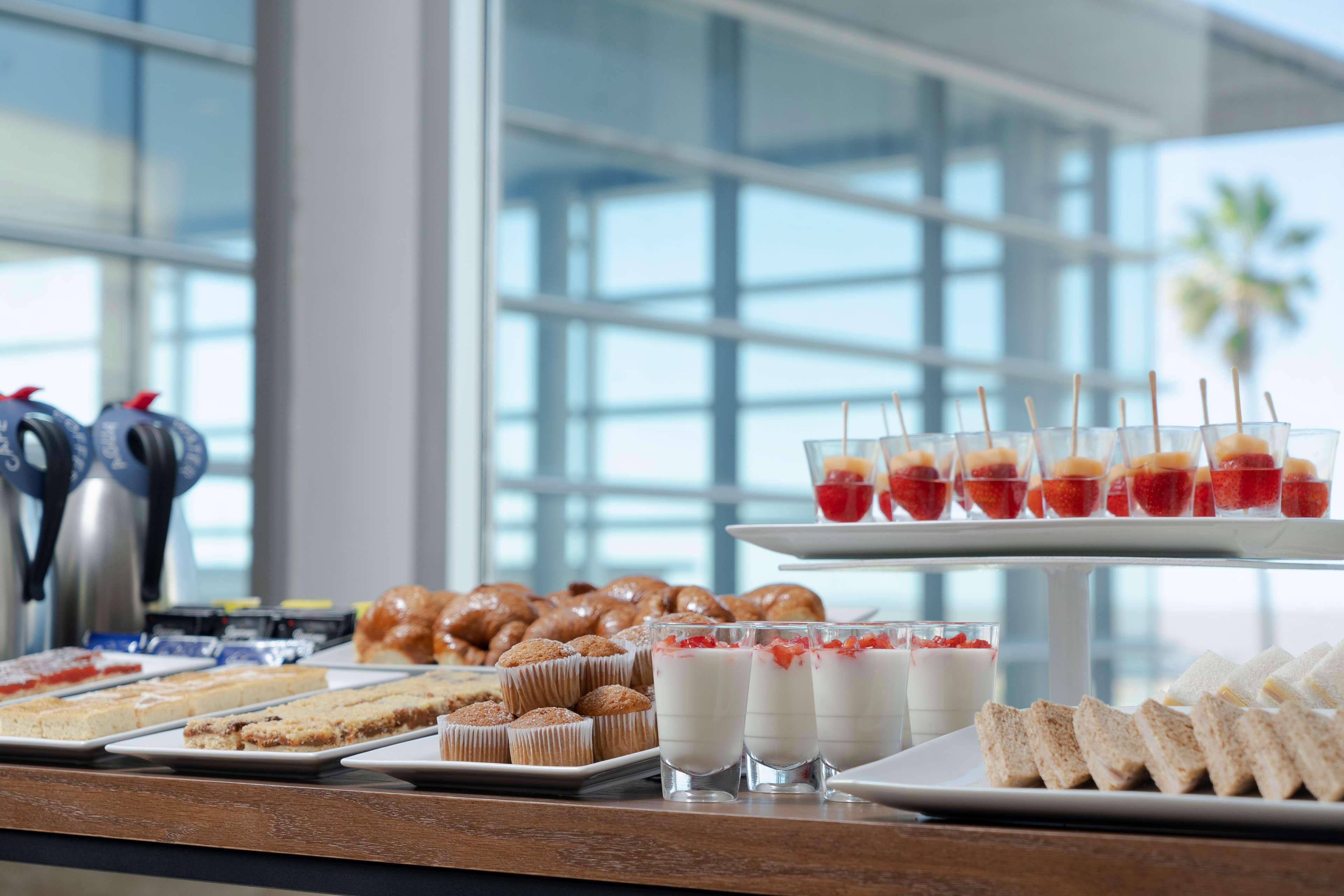 Un buffet con diverse pietanze, tra cui pasticceria, panini e dolci.