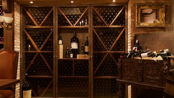 Una cava de vinos con estanterías de madera y un armario de madera lleno de botellas.
