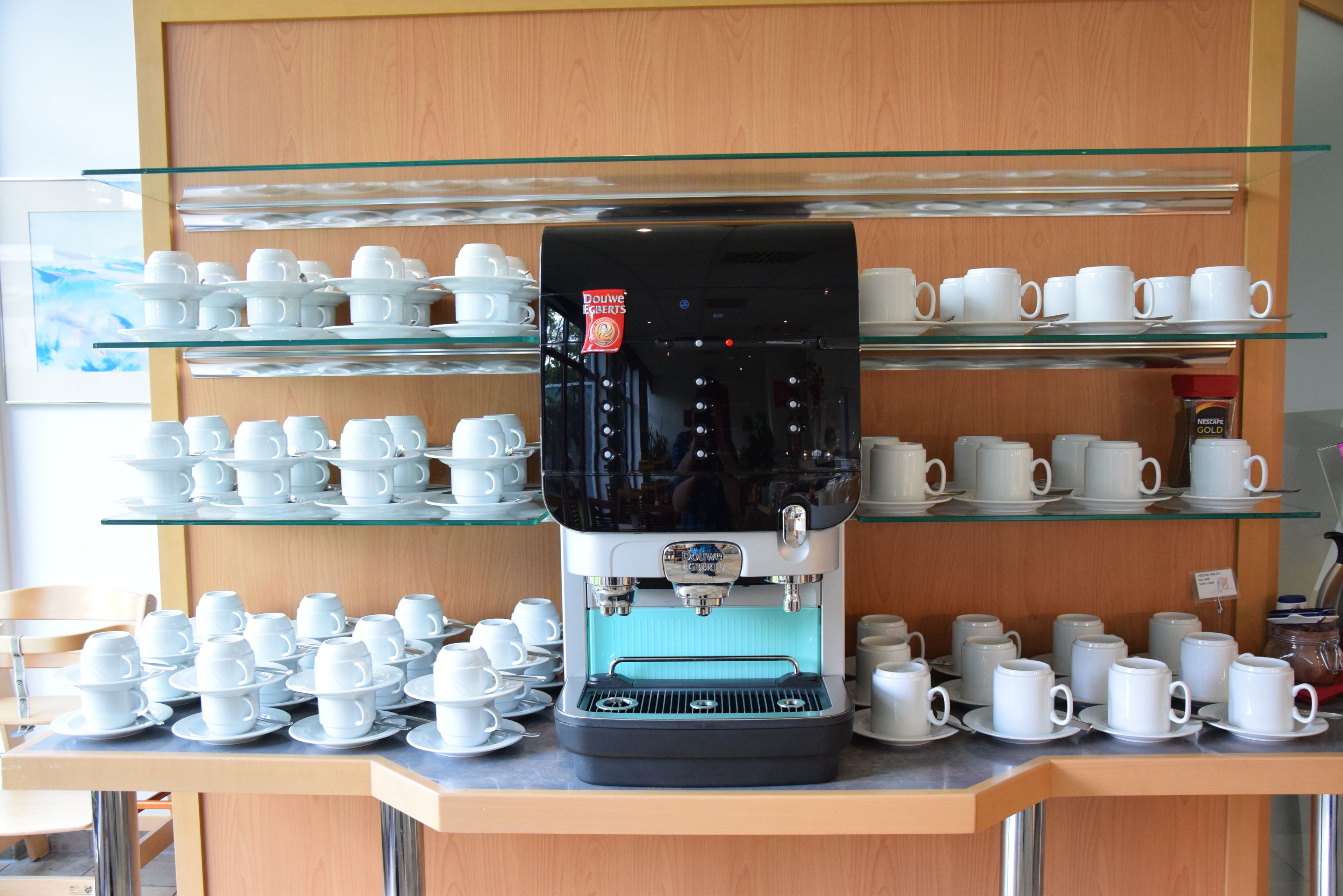 A coffee machine with multiple coffee cups and saucers on display.