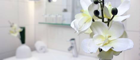 A bathroom with a white sink, mirror, and toiletries.