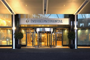 The entrance to Intercontinental hotel with a revolving door and glass doors. - InterContinental Malta by IHG (St. Julian's)