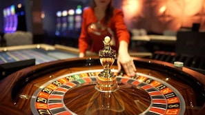 A roulette wheel with a dealer in the background. - InterContinental Malta by IHG (St. Julian's)