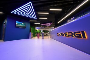 A modern interior with a prominent CYWERG1 sign, a digital display, and a geometric light installation on the ceiling. - InterContinental Malta by IHG (St. Julian's)