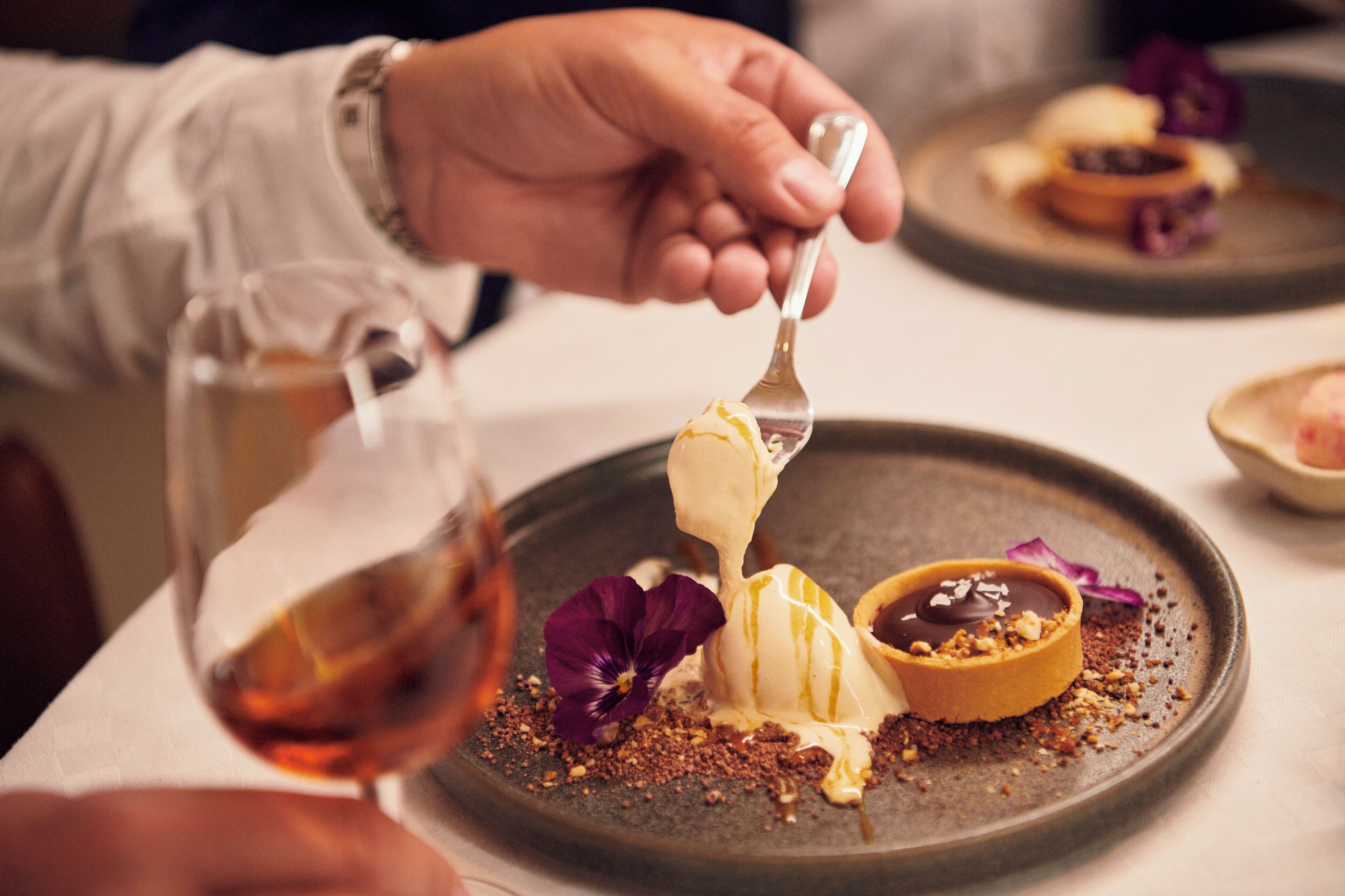 Une personne servant un dessert dans une assiette à l’aide d’une fourchette.