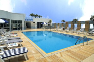 Una piscina al aire libre de temporada, sillones reclinables de piscina