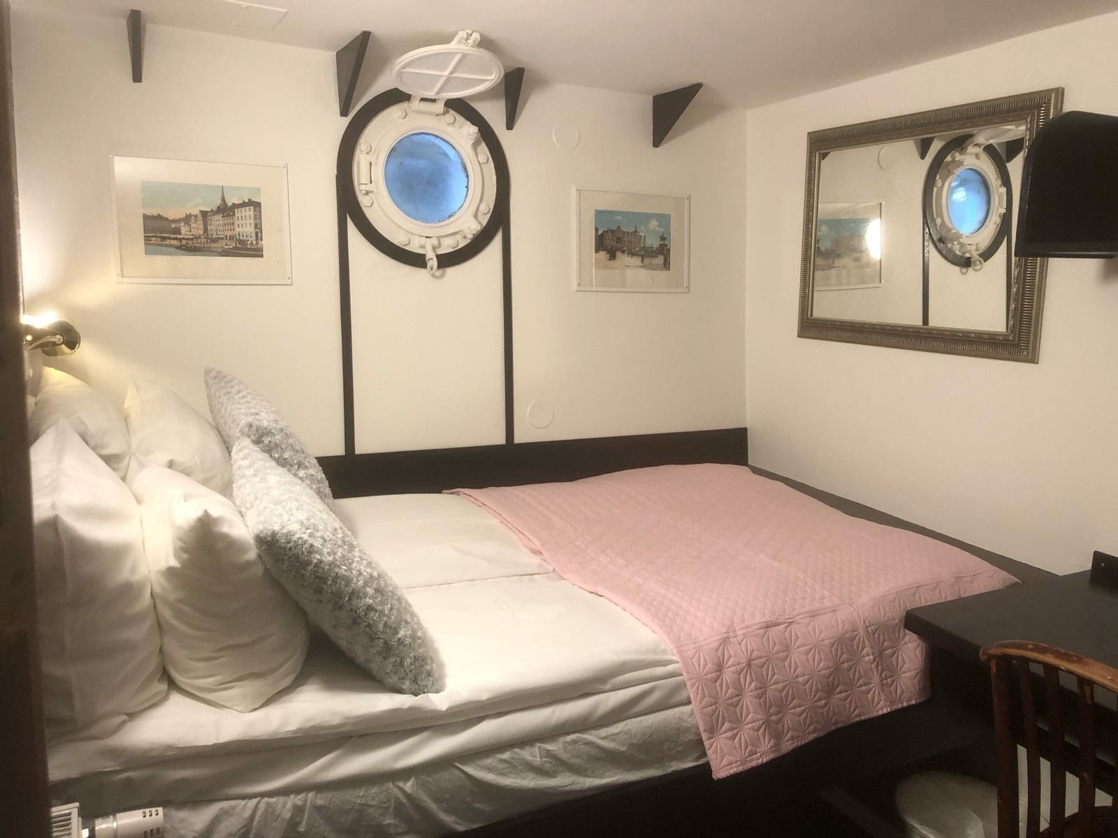 Un dormitorio con cama, un escritorio y dos cuadros en la pared.