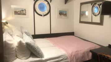 Un dormitorio con cama, un escritorio y dos cuadros en la pared.