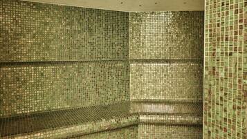 A room with a tiled wall and a bench.