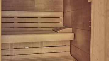 A sauna with wooden benches and a tiled wall.