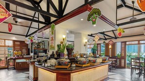 A buffet area with a variety of food items and decorative elements like hanging vegetables and plants.