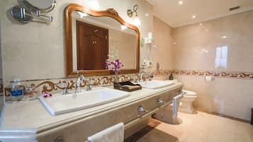 Ein Badezimmer mit zwei Waschbecken, einer Toilette, einem großen Spiegel und einem Handtuchhalter.