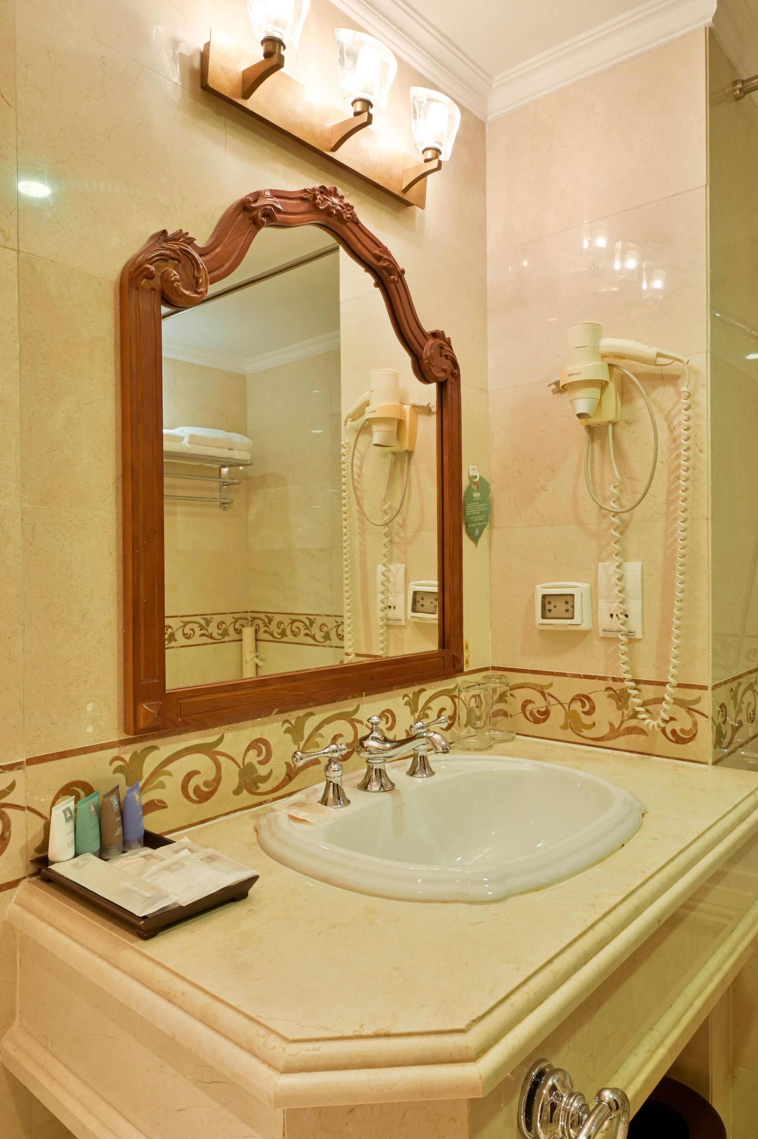 A bathroom with a large mirror, a sink, and a vanity.