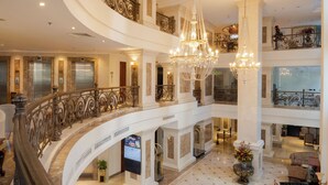 A multi-level hotel lobby with a grand staircase, chandeliers, and a marble floor. - Hotel Grand Saigon (Ho Chi Minh City)