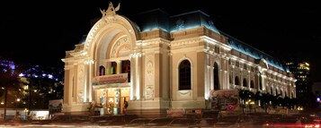 A grand building with classical architecture, featuring a prominent arched entrance and columns.