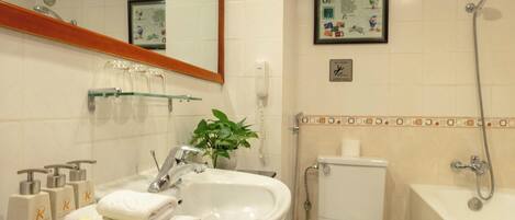 Un bagno con lavandino, specchio, WC e doccia.