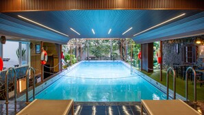 A swimming pool with a wooden ceiling and metal railings. - Royal Hotel Saigon (Ho Chi Minh City)