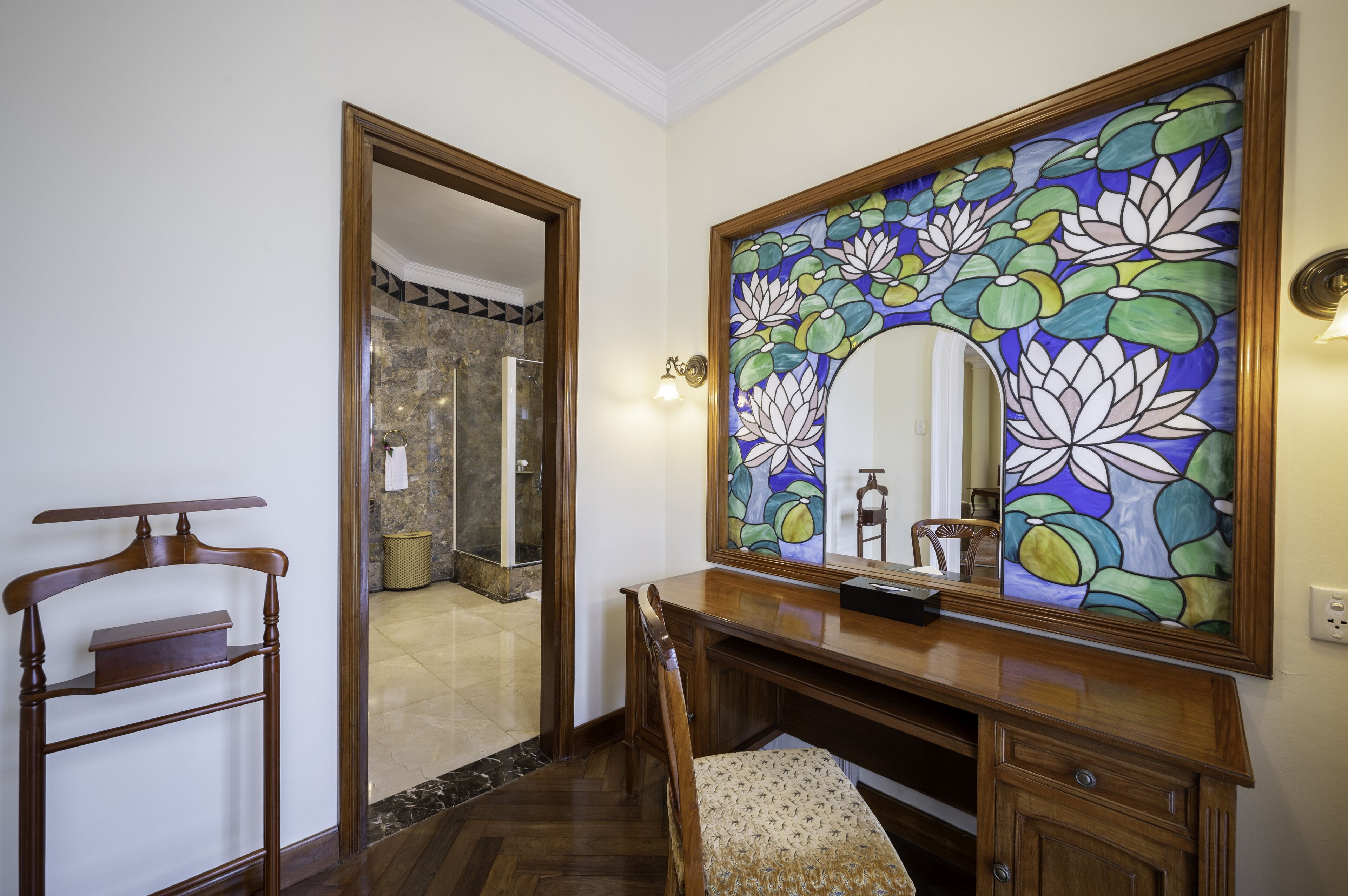 A bathroom with a wooden vanity, a mirror, and a stained glass window.