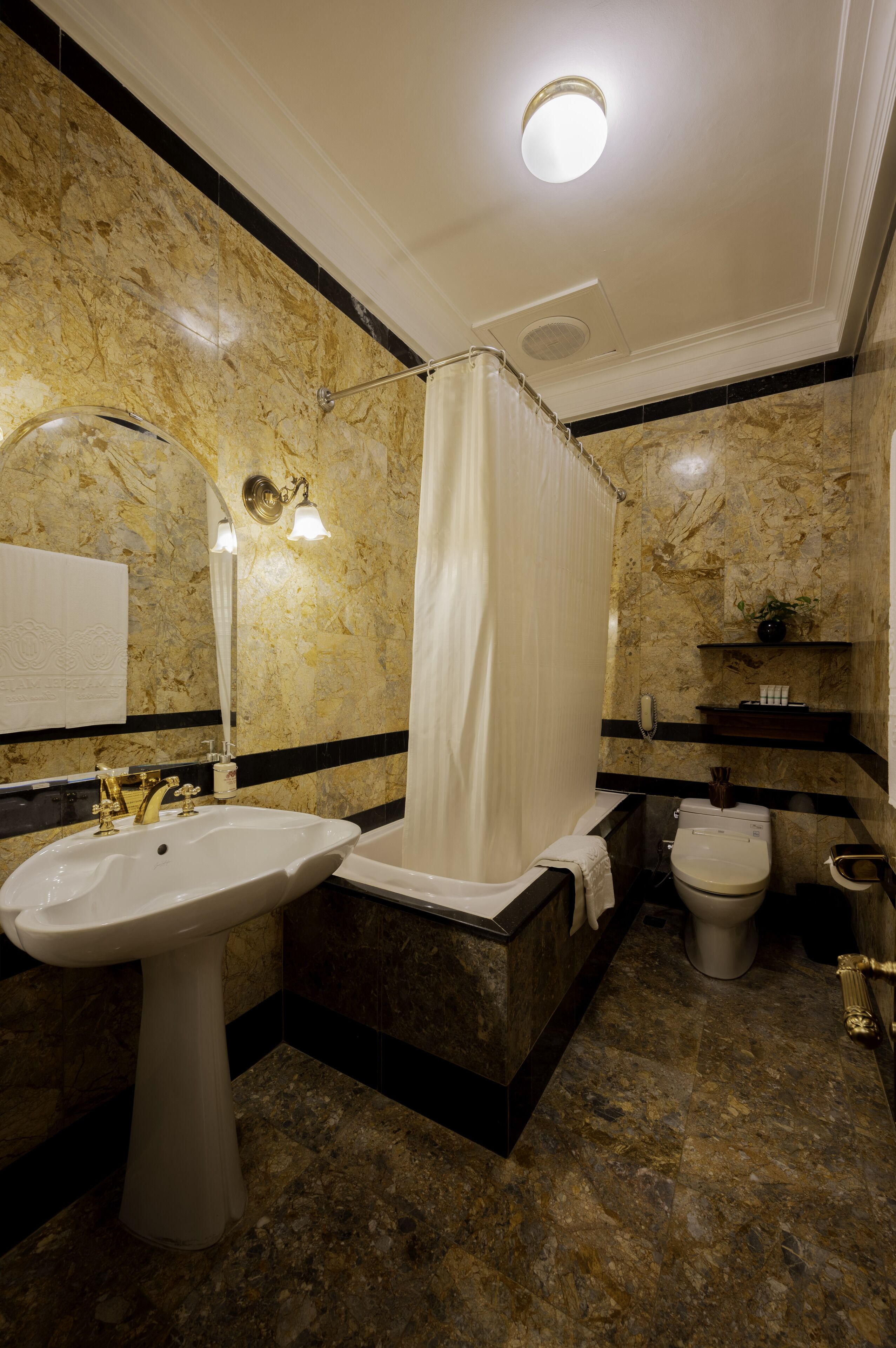 A bathroom with a marble sink, a bathtub, and a toilet.