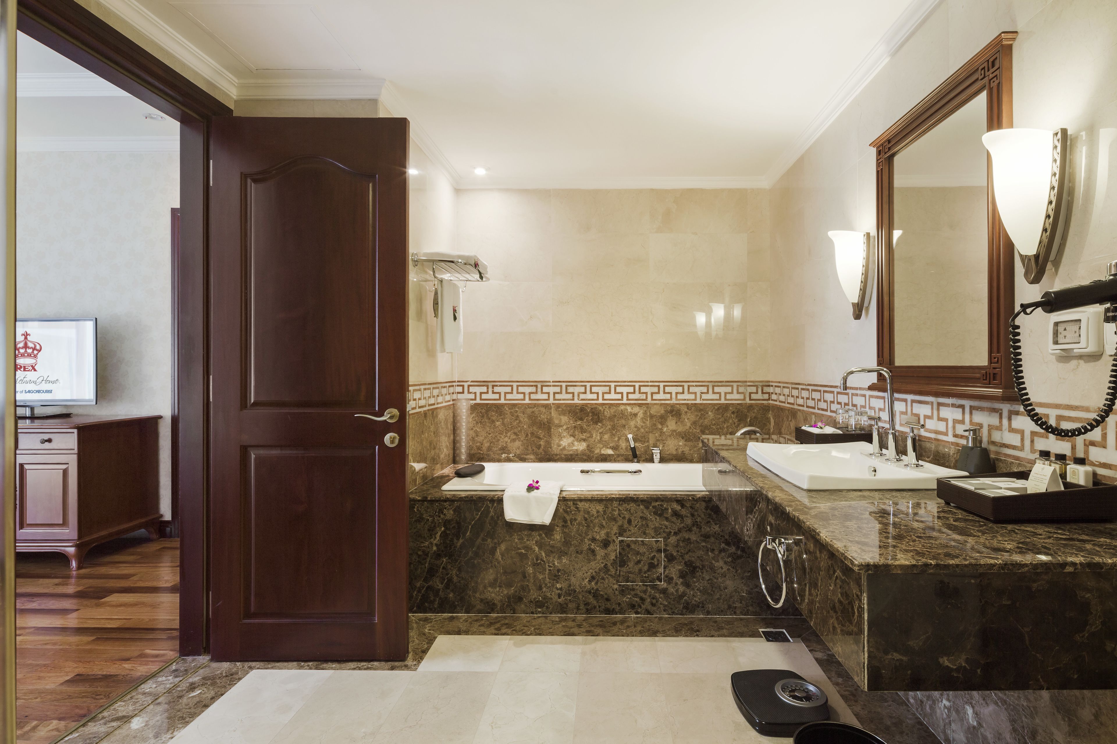 A modern bathroom with a marble vanity, a large mirror, and a separate sink.