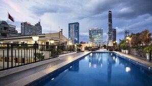 Una piscina con un paisaje urbano de fondo, que incluye modernos rascacielos.