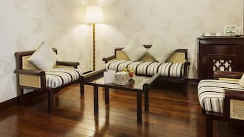 A traditional living room with two sofas, a coffee table, and a lamp.