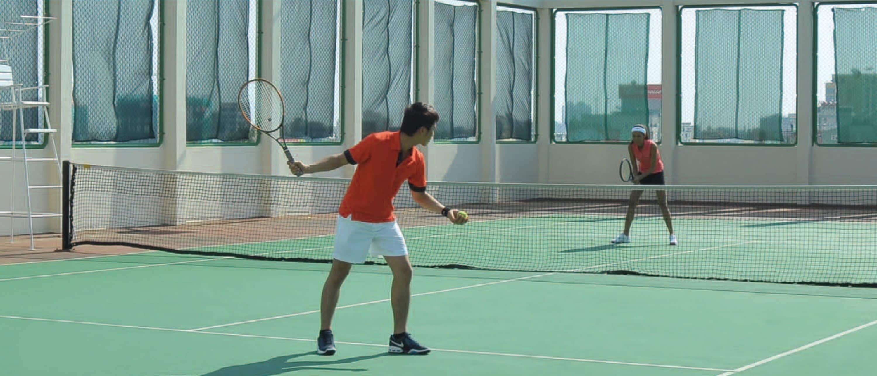En tennisbane med net, to spillere og en stige.