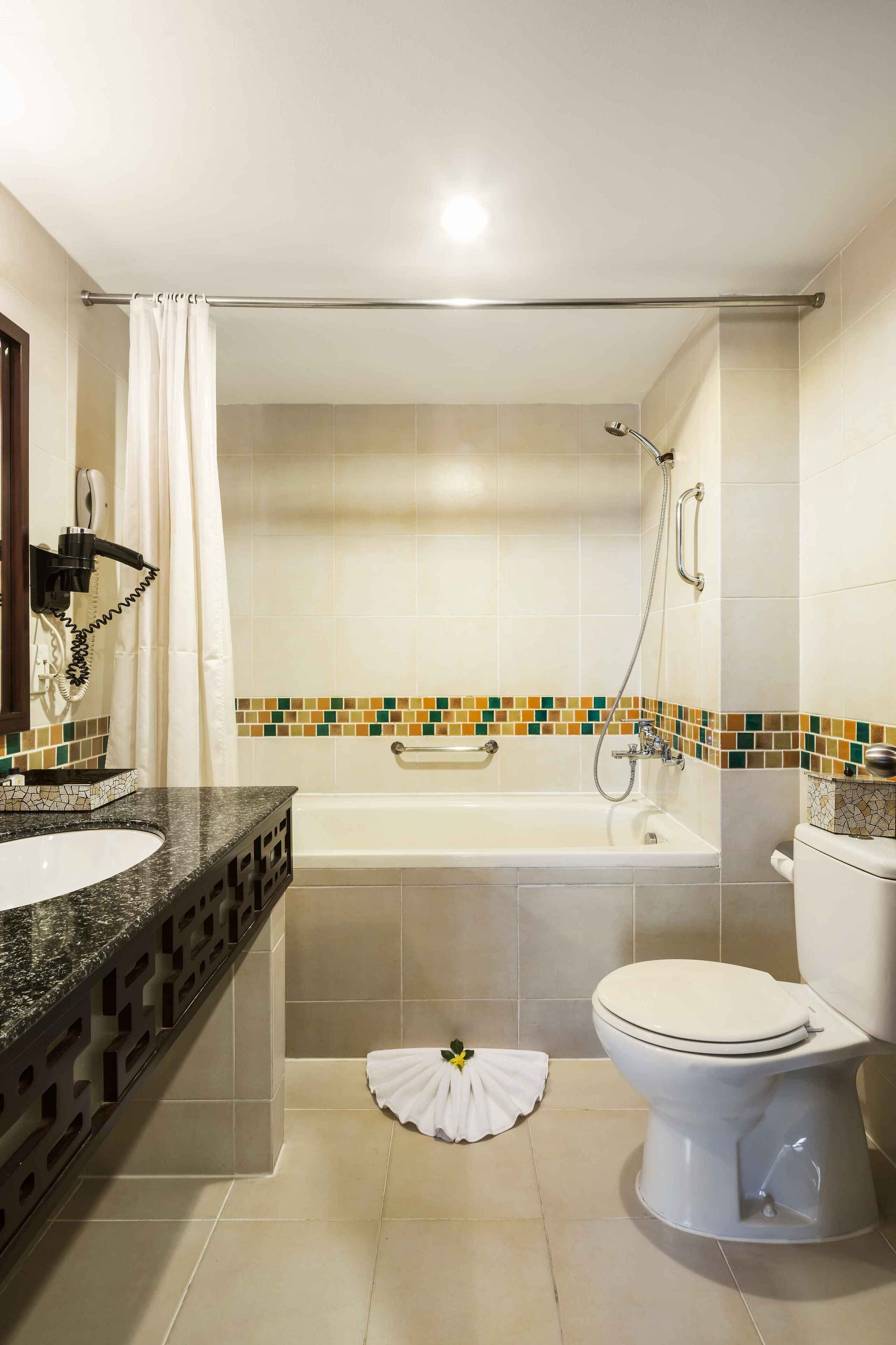 Un baño con bañera, inodoro y lavamanos.