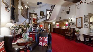 A grand lobby with a red carpet, a staircase, and a reception area. - The Castle at Taunton (Taunton)