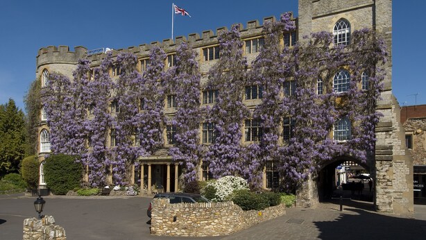 A historic building with a stone facade, large windows, and a flag. - The Castle at Taunton (Taunton)