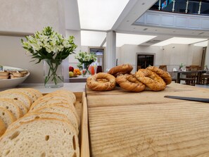 Buffet de café da manhã com pães, doces e flores.