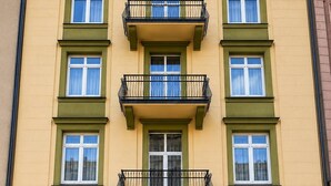 Un edificio de hotel con entrada central, varios balcones y un letrero con el nombre.