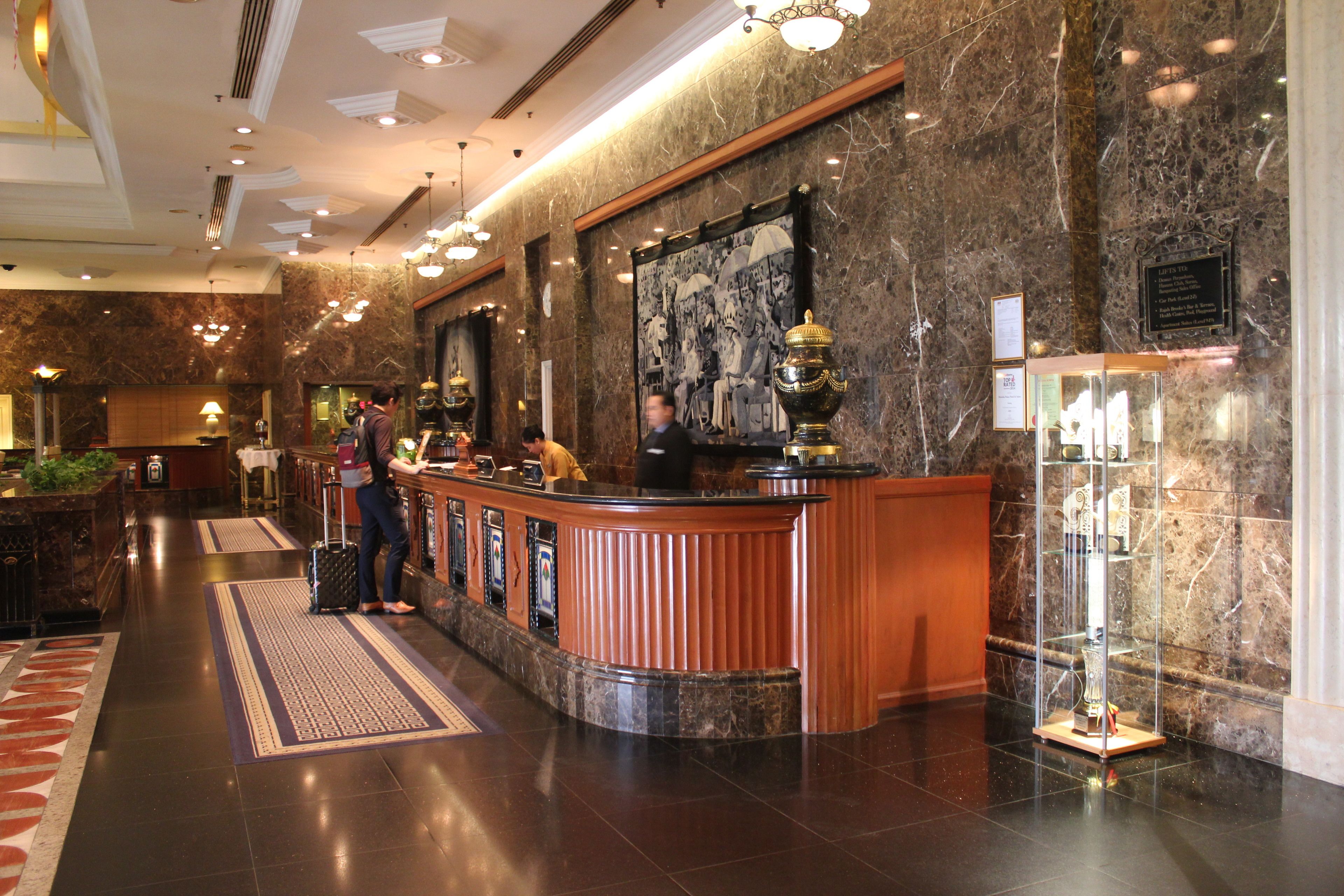 A lobby with a reception desk, a large framed picture, and a display case with items.