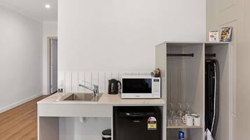 A compact kitchenette with a microwave, coffee maker, and a small refrigerator.
