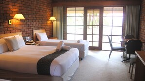 A hotel room with two beds, a desk, and a chair.