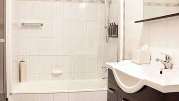A modern bathroom with a shower, a sink, and a vanity with drawers.