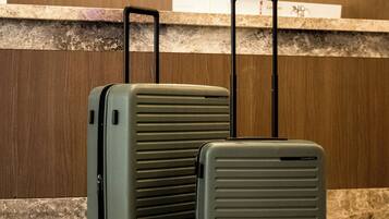 Two suitcases on a tiled floor with a wooden wall and a light in the background.