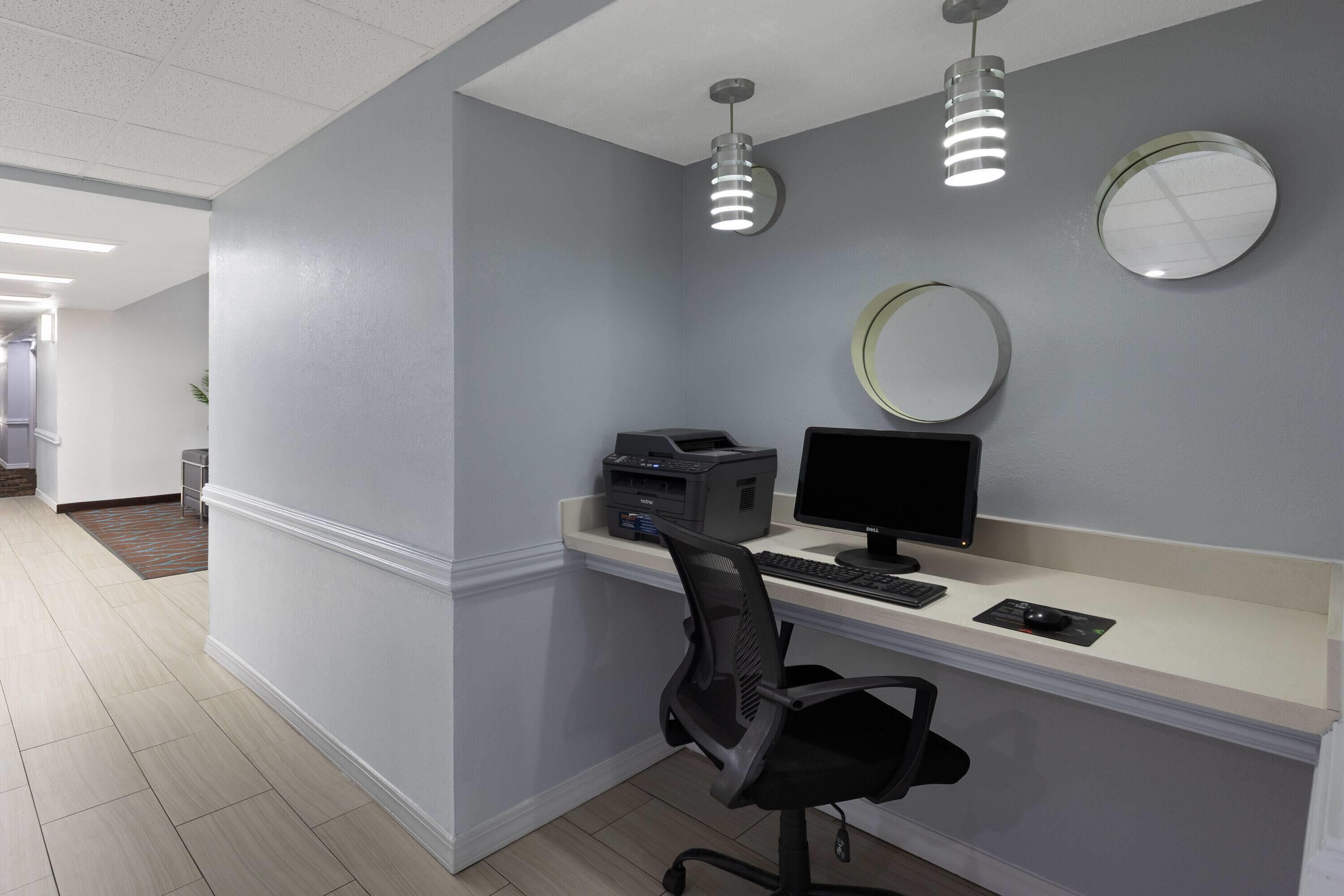 Un espacio de oficina moderno con un escritorio, computadora, impresora y silla.