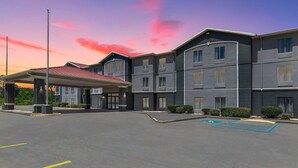 A multi-story hotel with a covered entrance and a parking area. - Baymont by Wyndham Moss Point/Pascagoula (Moss Point)