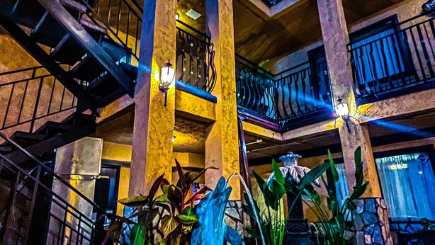 A multi-level hotel with a central courtyard featuring a fountain and potted plants. - Hotel Baja San Diego - A Boutique Hotel (San Ysidro)