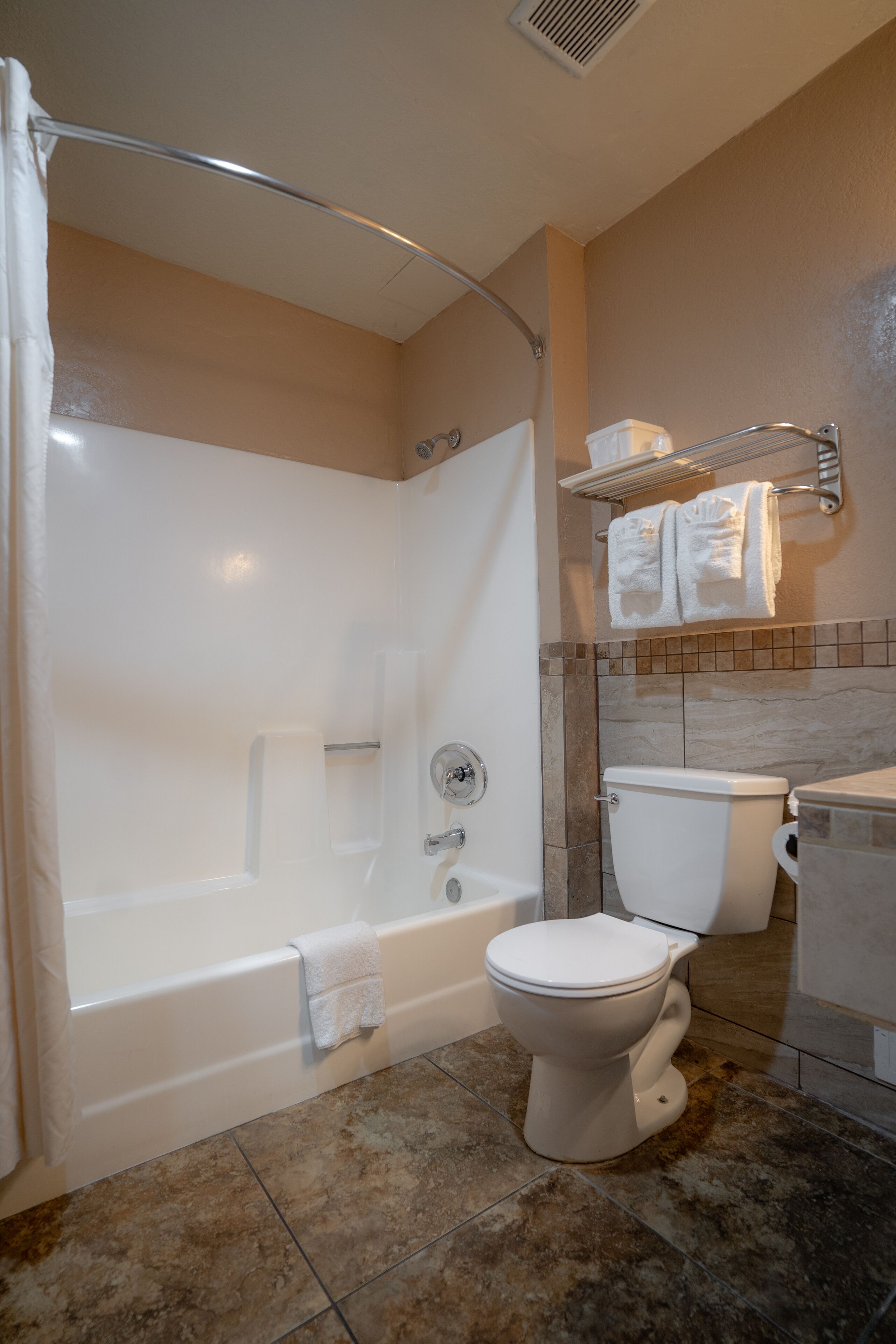 A bathroom with a bathtub, toilet, and shower curtain.