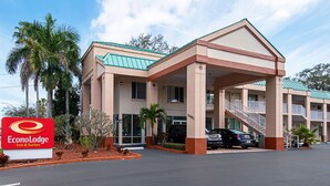 A two-story EconoLodge Inn & Suites building with a green roof, palm trees, and a parking lot. - Econo Lodge Inn & Suites Clearwater Central (Clearwater)