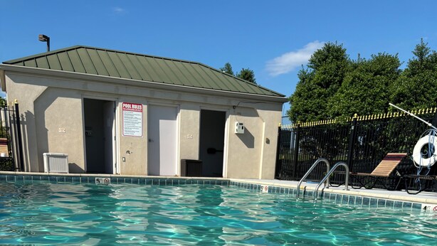A clear swimming pool with a lifebuoy and a signboard. - Baymont by Wyndham Johnson City (Johnson City)